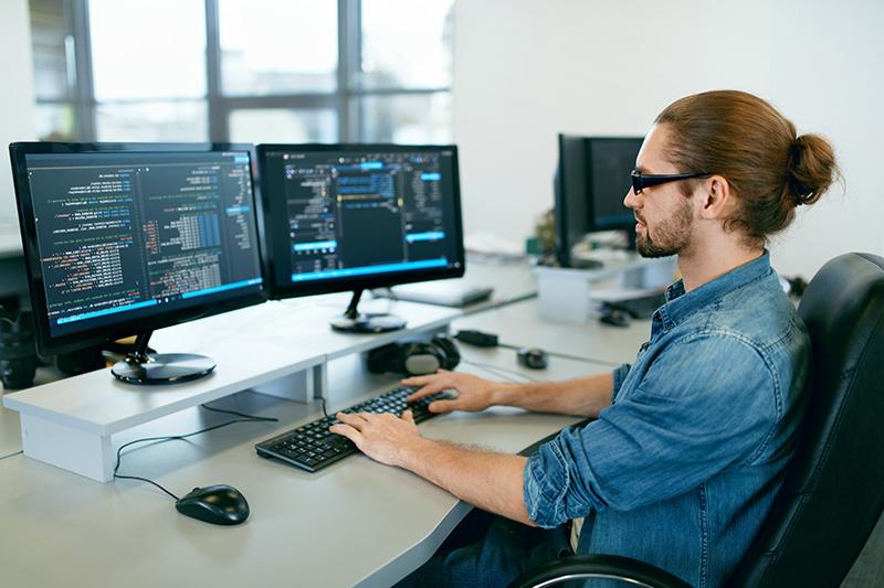 Programación. IT办公室的电脑工人, 坐在桌子上写代码. 程序员编写数据代码, 在一个软件开发公司的项目工作. Imagen de alta calidad.
